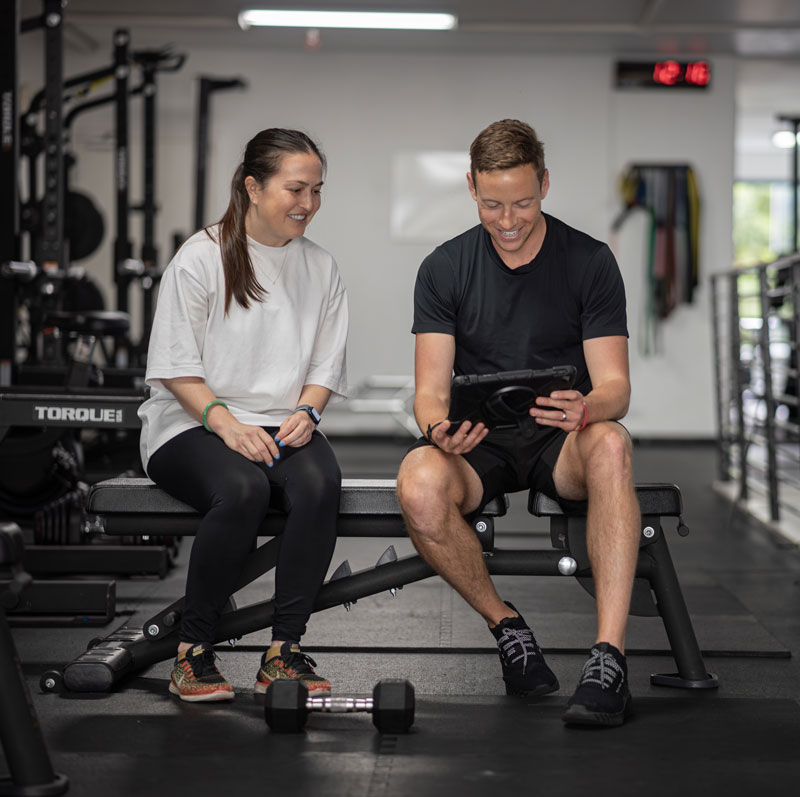 Ross reviewing a training plan with a client on a tablet